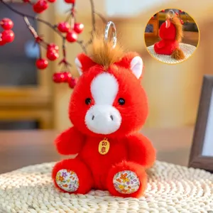 Dettaglio di un portachiavi a forma di cavallo di peluche rosso con accenti floreali e ciondolo