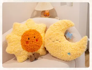 Soft plush sun and crescent moon decorative pillows with cute faces on a cozy armchair