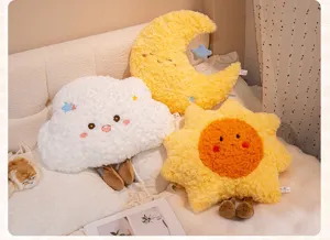Detailed view of cute plush cushions shaped like a smiling cloud, moon, and sun.