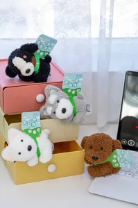 Macro detailed view of four cute colorful plush dog keychains displayed on desk drawers.