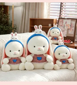 Vista dettagliata di una collezione di morbidi peluche di coniglio bianco con cerchietti blu.
