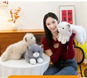 Detail shot of a model holding a fluffy white plush cat toy in a warm home setting