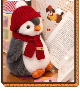 Vista detallada de un peluche de pingüino con gorro y bufanda de punto rojos vibrantes