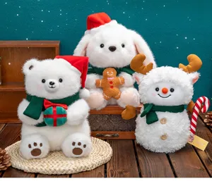 Set di tre peluche natalizi: orso, coniglio e pupazzo di neve su un tavolo di legno