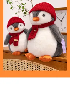 Vista detallada de dos lindos peluches de pingüino con gorros y bufandas de punto rojos