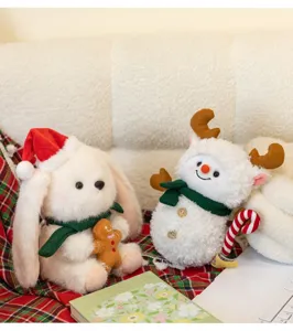Primo piano di peluche festivi a forma di pupazzo di neve e renna su una coperta