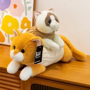 Vista detallada de dos lindos gatos de peluche con suéteres de punto en un mueble de madera.