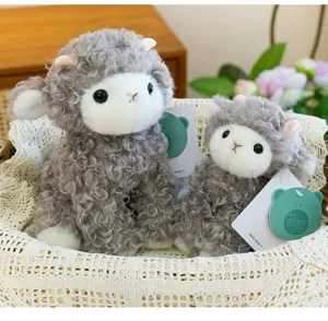 Detailed close-up of two soft grey curly-haired lamb plush toys sitting in a woven basket