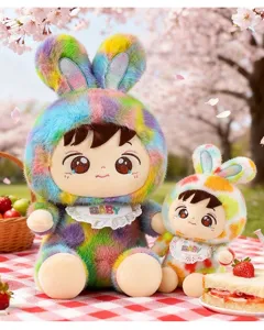 Niedliches Paar Regenbogen-Hasen-Plüschpuppen mit BABY-Lätzchen in Kirschblüten-Picknick-Szene