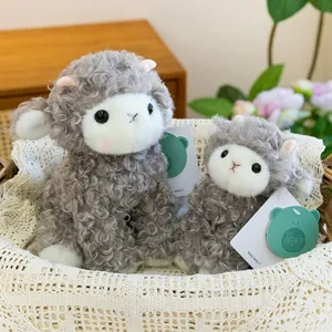 Adorable pair of soft curly grey sheep plush toys sitting in a decorative lace basket