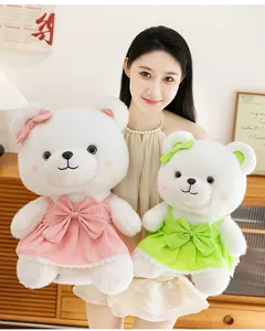 Two cute white plush bears wearing pink and green princess dresses held by a model