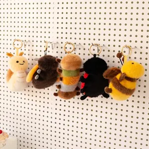 Set of five cute cartoon insect plush toy keychains hanging on a white display board