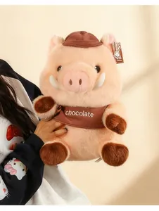 Close-up of a cute pink wild boar plush toy wearing a brown hat and chocolate shirt