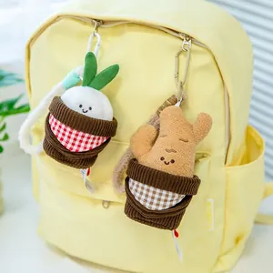 Süße Plüsch-Ingwer- und Knoblauch-Taschenanhänger an einem gelben Rucksack dekoriert