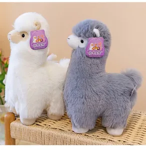 Macro view of soft white and grey alpaca plush toys sitting on a woven chair for nursery decoration