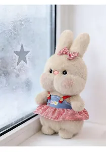 Close-up of cute plush rabbit doll wearing a red checkered skirt and blue denim style top