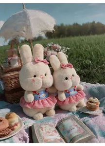 Detail of two cute plush bunnies in red checkered skirts at an outdoor picnic scene