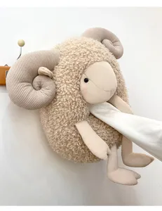 Detail view of a soft curly sheep plush toy hanging on a minimalist wall hook
