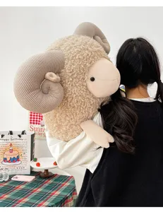 Detailed view of a large curly sheep plush toy with big spiral horns being held