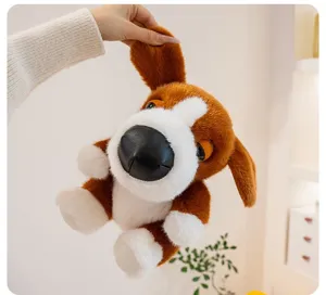 Hand holding an adorable brown and white big head dog plush toy puppy doll for kids
