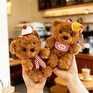 Two cute plush bear keychain pendants with striped scarves and hats in cafe setting