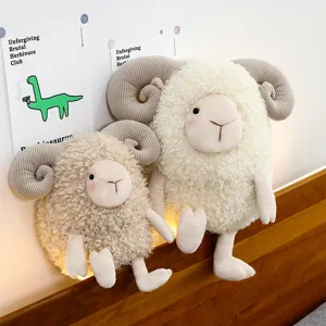 Curly wool sheep plush toy dolls in two sizes sitting on a wooden bed headboard.
