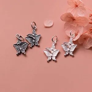 Macro detail of 925 sterling silver butterfly pendants in vintage and polished finishes