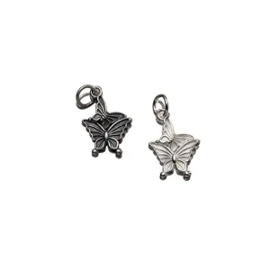 Close-up of vintage 925 sterling silver double butterfly charms with detailed texture