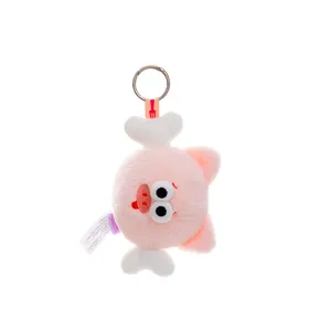 Detailed close-up view of soft pink plush cartoon pig keychain with white bone decor.