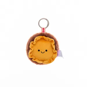 Close-up of cute plush character keychain with fluffy brown edges and yellow face