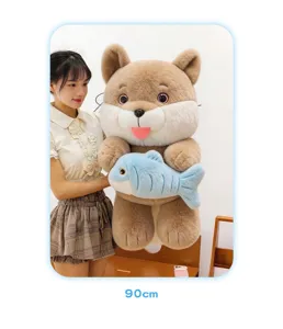 Detailed view of a large 90cm cute cat plush toy holding a blue fish held by a model