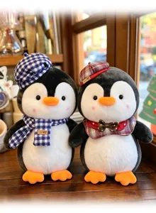 Detailaufnahme zweier süßer Pinguin-Plüschtiere mit karierten Hüten und Schals im Café