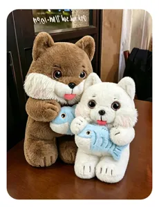 Detailed view of cute brown and white cat plush toys holding blue fish on a wooden table.