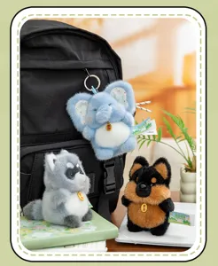 Variety of cute plush animal keychains hanging on a black backpack in a cozy room.