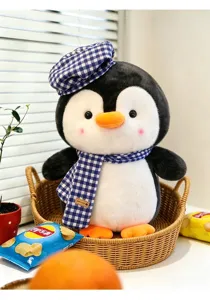 Detailansicht eines süßen Pinguin-Plüschtiers mit blau-weiß kariertem Hut und Schal