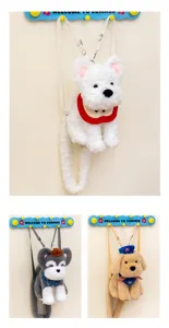 Detalle de lindos mochilas de peluche para perros en blanco, gris y tostado en un perchero.