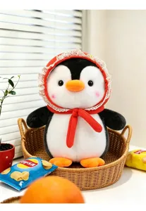 Detailansicht eines süßen Pinguin-Plüschtiers mit rotem Hut mit Spitzenbesatz im Korb.