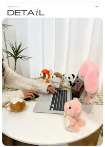 Adorable variety of animal plush charms displayed around a laptop on a desk in a lifestyle view
