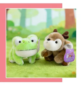 Detalle de tiernos peluches de rana verde y ciervo marrón en un entorno de bosque