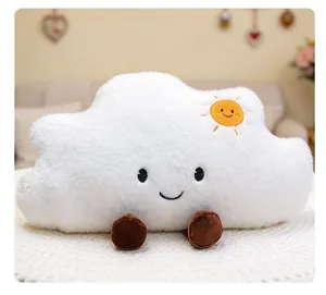 Vista detallada de un suave cojín de peluche nube blanca con sol y cara sonriente