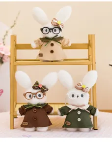 Close-up of three white plush rabbit dolls wearing glasses and colorful vintage-style dresses