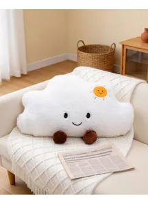 Lindo cojín de felpa con nube sonriente en un sofá crema en un ambiente hogareño