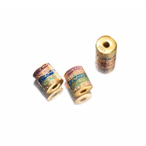 Close-up of S925 gold-plated barrel beads with colorful enamel and scripture patterns.