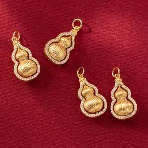 Detailed view of rotatable gold plated gourd pendants with zircon micro-pave on red fabric