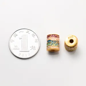 Detailed macro view of 925 sterling silver gold-plated scripture barrel bead with coin for scale