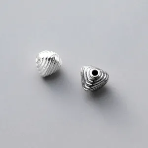 Macro view of 925 sterling silver geometric triangle beads with vintage striped texture.