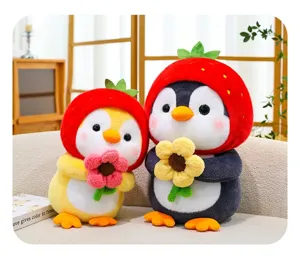 Two cute plush penguin toys wearing strawberry hats and holding flowers on a sofa