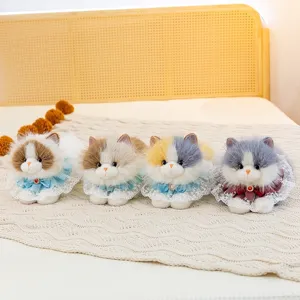 Four cute simulation Ragdoll cat plush dolls with lace collars on a cozy bed.