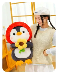 Close-up of cute penguin plush toy with strawberry hood held by an Asian woman in detail
