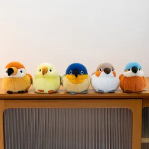 Set van vijf schattige ronde pluche vogels tentoongesteld op een houten dressoir in huis